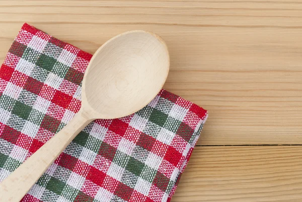 Wooden spoon and a checkered napkin — Stock Photo, Image