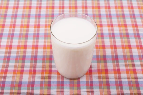 Glas Milch auf der Tischdecke. — Stockfoto