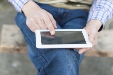 tablet sokakta elinde olan adam.