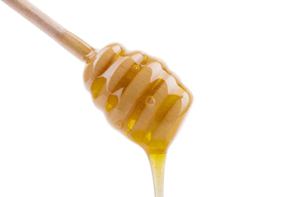 Honey dripping from a wooden spoon. — Stock Photo, Image