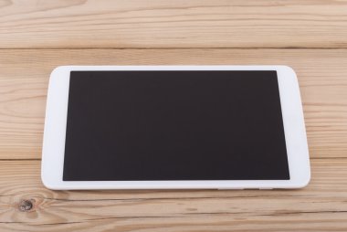 ahşap zemin üzerinde boş bir ekran ile tablet bilgisayar.