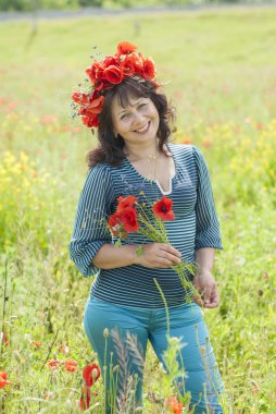 haşhaş çiçekleri olan bir alana kadında.