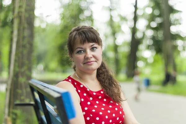 Porträtt av en vacker flicka på en parkbänk. — Stockfoto