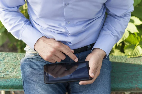Man with tablet in hand in park. — Stock Photo, Image
