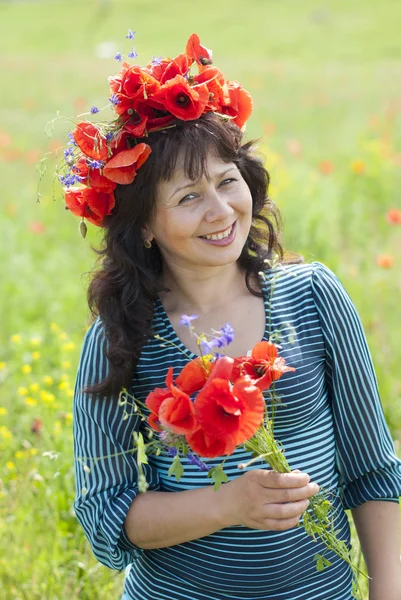 Mulher em um campo com flores de papoula . — Fotografia de Stock