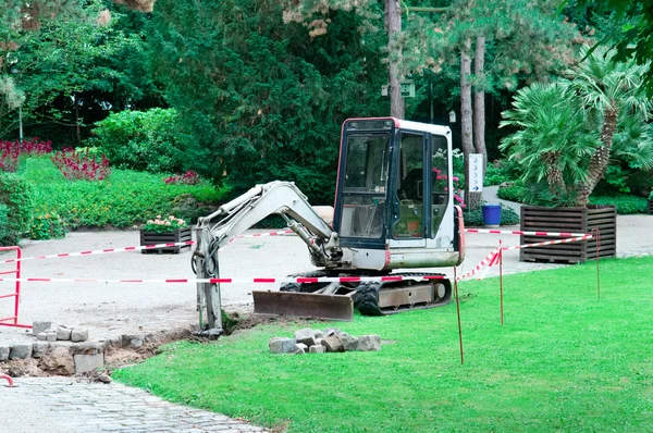 Liten grävmaskin arbetar i parken — Stockfoto