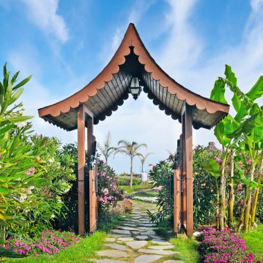 Çardak, palmiye ağaçları ve mavi gökyüzü