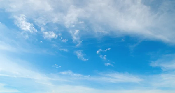Pörröiset pilvet sinisellä taivaalla — kuvapankkivalokuva