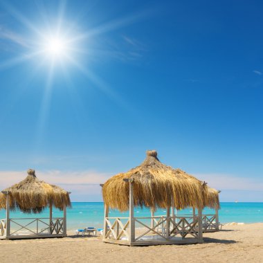 plaj, bungalovlar, mavi gökyüzü ve güneş