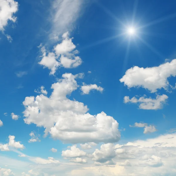 Mavi gökyüzünde beyaz bulutlu güneş — Stok fotoğraf