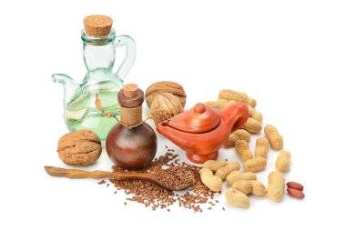 Ceviz ve fıstık, keten tohumu ve beyaz arka planda izole edilmiş bir çift sebze yağı..