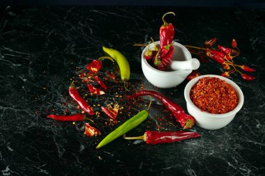 Siyah arka planda acı biber tozu ve biber tozu..