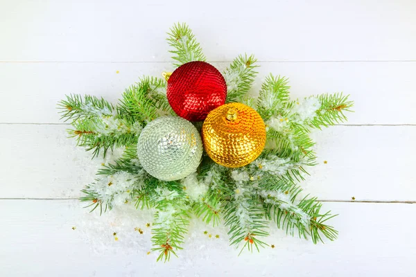 Ein Zweig Tanne Bunte Weihnachtskugeln Und Schnee Auf Weißem Holzgrund — Stockfoto