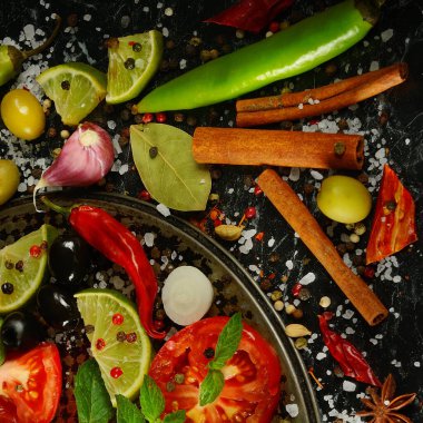 Karanlık bir masada bir sürü farklı baharat ve aromatik otlar. Yukarıdan görüntüle.