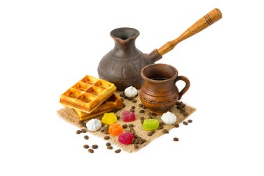 Bir fincan kahve, kahve demliği, waffle, kahve çekirdekleri ve beyaz arka planda izole edilmiş marmelat şekeri..