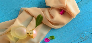 İpek eşarp ve parfüm şişesi mavi kaliteli arka planda. Geniş resim.