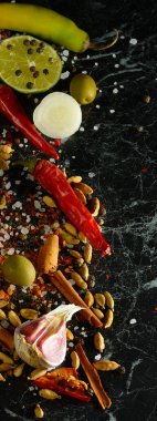 Karanlık bir masada bir sürü farklı baharat ve aromatik otlar. Yukarıdan bak. Dikey fotoğraf.