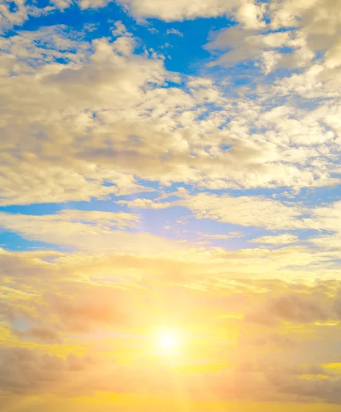 Beautiful sky with bright sunset (sunrise) and light clouds. Vertical photo.