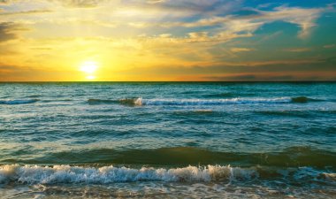 Renkli okyanus plajlı dalgalar kıyıya vuruyor. Deniz zemininde gün doğumu.