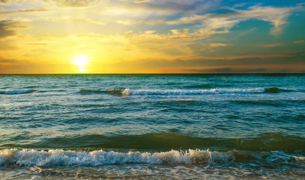 海浪翻滚在海岸上 与五彩斑斓的海滩相伴 海背景上的日出 — 图库照片