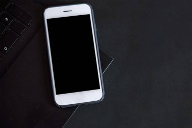 Akıllı telefon ve bilgisayar tuş takımı siyah bir masada, kapat