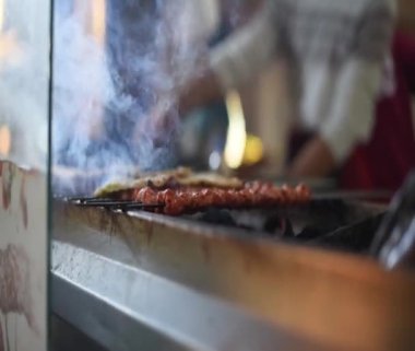 Geleneksel Adana kebabı Türkiye 'nin Adana kentinde bbq ve sigara ile ızgara yapıyor. 03.28.2022