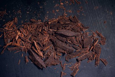 Siyah tahta bir levhada kırılmış siyah çikolatalar, yakın çekim, makro fotoğraf.