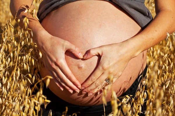 Pregnant belly with heart — Stock Photo, Image