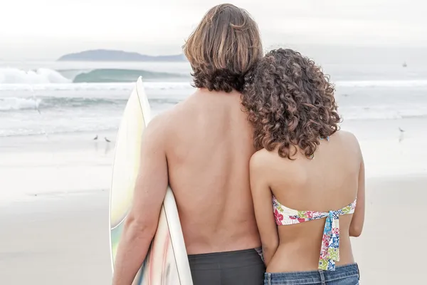 Pareja surfista en la playa — Foto de Stock