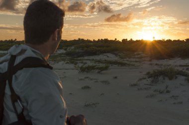 Hiker observes sunset clipart