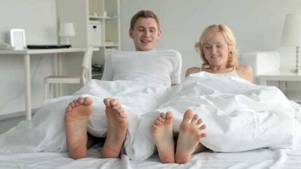 Игривая пара в постели — стоковое видео