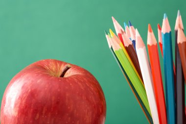 renkli kalemler ve elma