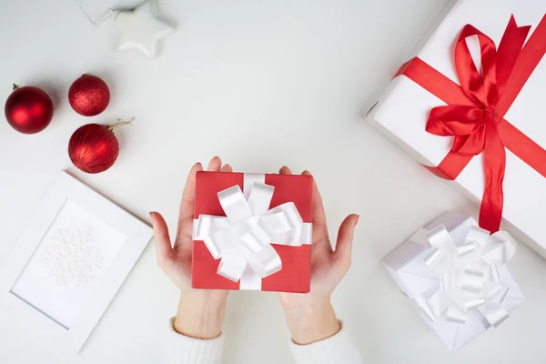 Christmas present on palms — Stock Photo, Image