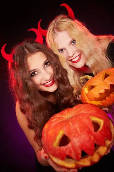 Meisjes tonen gesneden halloween pompoenen — Stockfoto