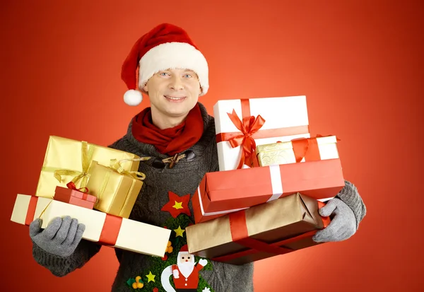 Man in santa cap met giftboxes — Stockfoto