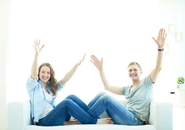 Casal alegre sentado no sofá — Fotografia de Stock