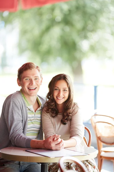 Happy guy and his girlfriend sitting in cafe — Stock Photo, Image