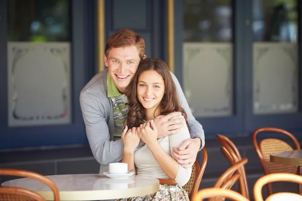 Killen som omfamnar sin flickvän i café — Stockfoto