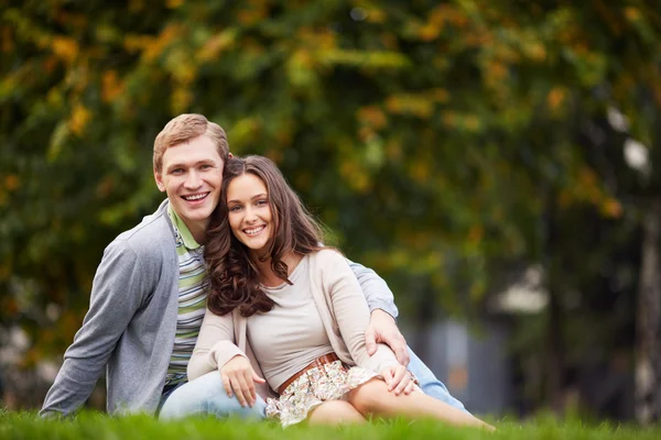Glad tjej och hennes pojkvän i park — Stockfoto