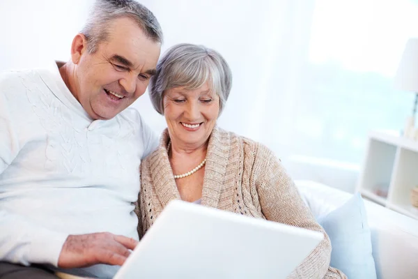 Mature man and his wife working with laptop — Stock Photo, Image