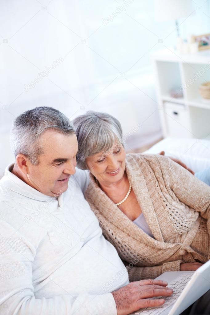 Mature man and his wife working with laptop