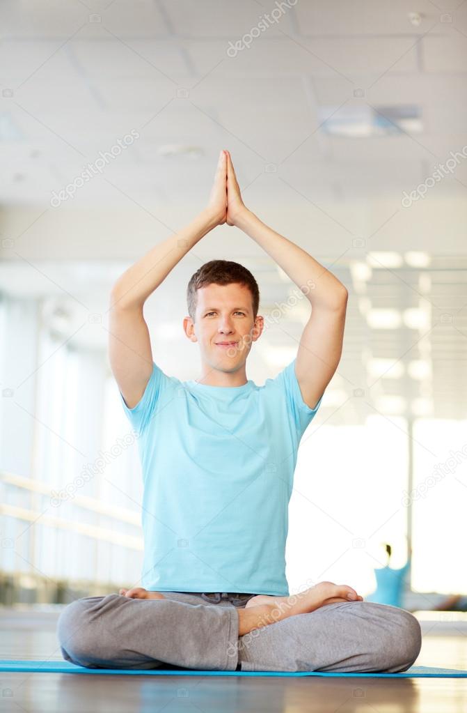 Man doing yoga exercise in gym