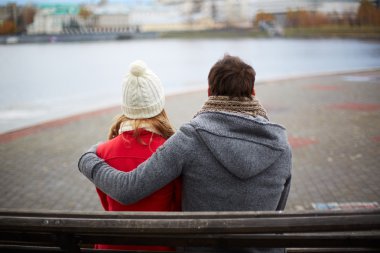 bankta oturan ve nehirde arayan couple