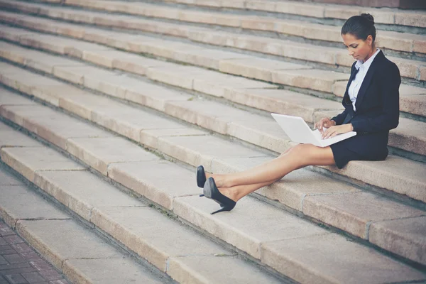 Businesswoman in suit networking on steps of building — Stock Photo, Image