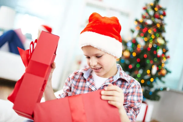 Junge schaut in große rote Geschenkbox — Stockfoto