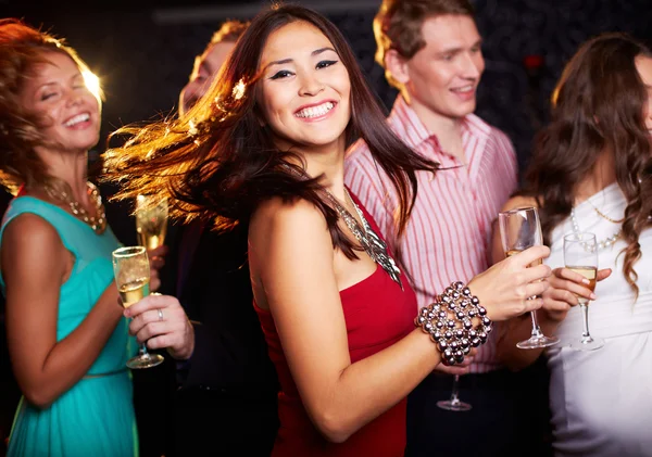 Веселая девушка с танцами на флейте шампанского — стоковое фото