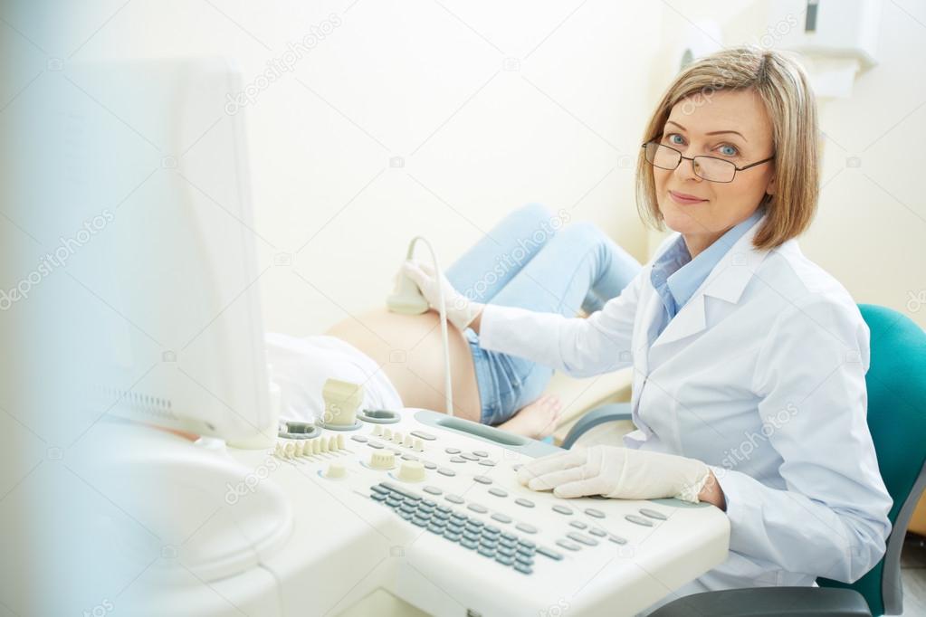 Mature doctor making an ultrasound