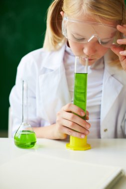kimyasal sıvı okuyan kız öğrenci