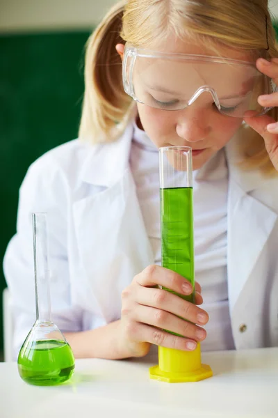 Schoolgirl studying chemical liquid — Stock Photo, Image