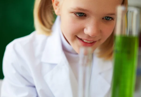 Schoolgirl studying chemical liquid — Stock Photo, Image